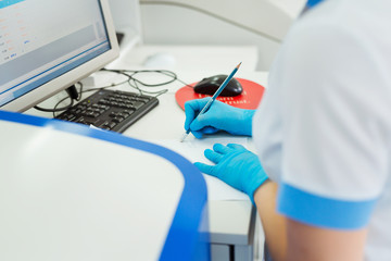 Obraz na płótnie Canvas Scientist entering data of blood sample in computer at laboratory