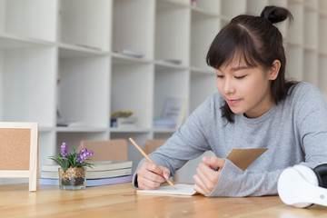 asian girl female teenager studying at school. Student writing note in cafe - education and learning concept
