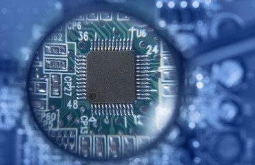 Circuit board with electronic components through a magnifying glass. Computer and networking...