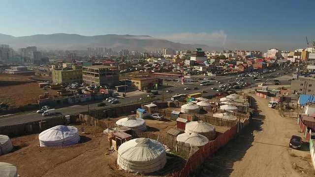 Aerial flight above Mongolia capital Ulaanbaatar. Gandan Gandantegchinlen Monastery at background. Endless yurts traditional houses nomads. Sunny day blue sky. 4k drone low roofs Cinematic movie