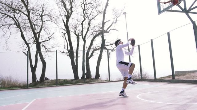 Two basketball player playing basketball outdoors, slow motion