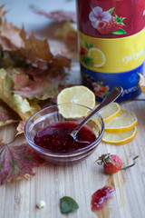 Raspberry jam and lemon rings against the background of autumn leaves