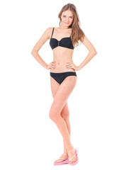 Fototapeta premium Sexy young woman posing in a black bikini, isolated on white background