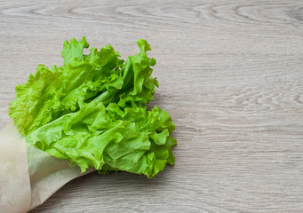 Leaves of green salad on a wooden background. View from above