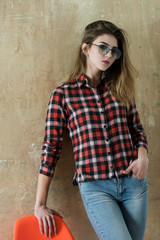 Pretty girl in glasses wearing red plaid shirt and jeans