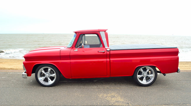 Classic Red  American pickup truck on seafront promenade.