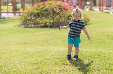 Fototapeta premium cute baby boy playing on green grass