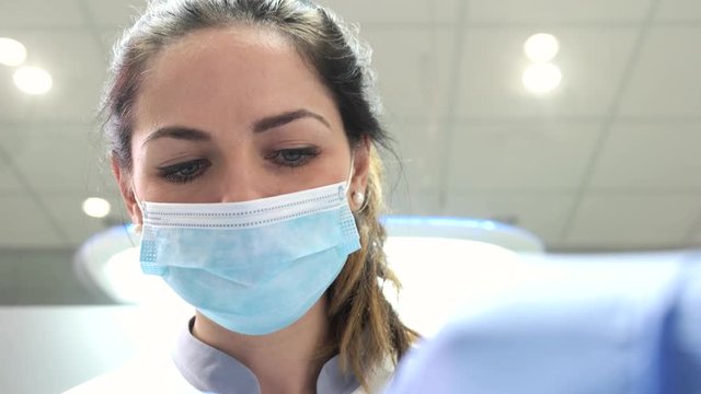 Young female stomatologist working. Face of doctor woman, mask.