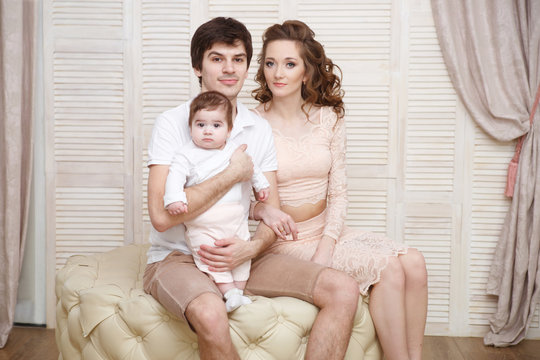 Happy young family, mother, father and baby.