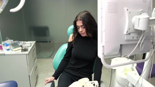 Woman in office of dentist. Lady sitting indoor. Consultation, diagnosis and treatment.