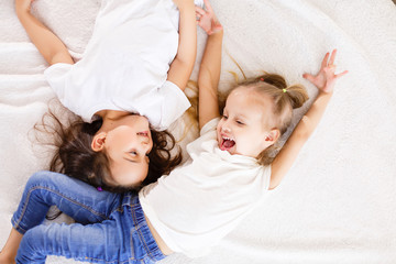 happy little girls lying on back top view sisters