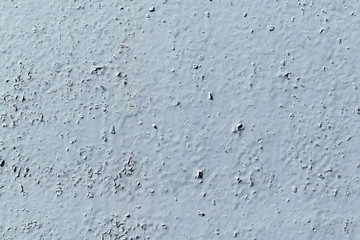 Wall painted with gray paint. The paint is chipping.