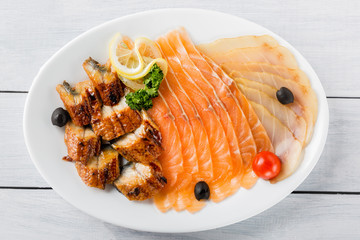 Salmon fillet pieces, conger eel, sturgeon pieces served with lemon, black olives, herbs and cherry...
