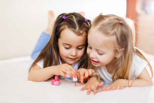 Two little girls painted their nails at home