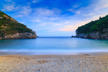 Fototapeta premium Long exposure landscape of Paleokastritsa famous sand beach in close bay on Corfu island at dusk, Ionian archipelago, Greece.