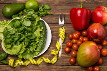 Healthy eating, dieting, slimming and weigh loss concept. Fruits and vegetables on wooden background