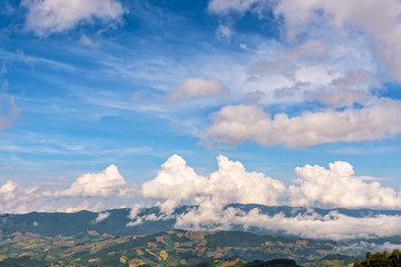 Beautiful cloudscape and blue sky above the high mountain range, There are hillside farming in Chiang Rai Province, Northern Thailand