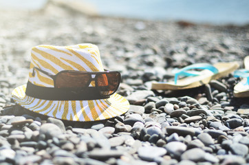 Hat, flip flops, glasses on the beach in the sun lights