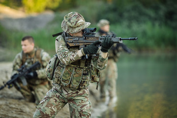 Special forces soldiers with weapon take part in military maneuver. war, army, technology and people concept.