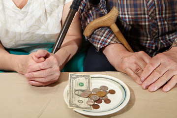 Poverty. Old couple and small coin.