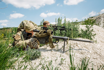 Army sniper during the military operation in the mountain. war, army, technology and people concept.