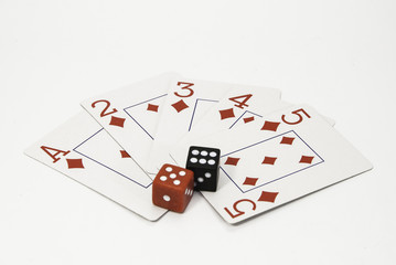 Red and white playing cards and a pair of black and red dice on a white background.