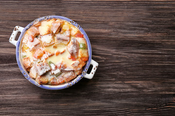 Freshly baked bread pudding in casserole dish on wooden table