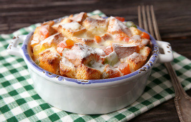 Freshly baked bread pudding in casserole dish on napkin