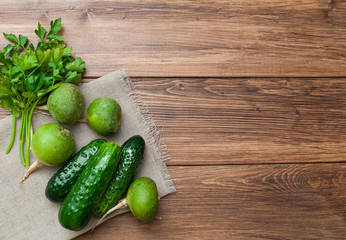 Green vegetables and salad on a wooden background. Top view with space for text