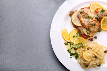 Plate with delicious Italian chicken piccata on table
