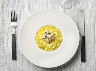Plate with rice and chicken on table