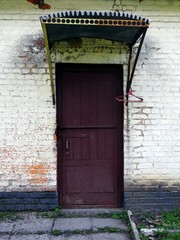 Старая коричневая дверь в кирпичной стене старого здания