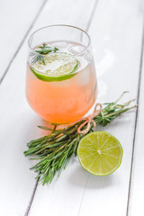 healthy morning with fresh drink, lime and rosemary on wooden table background