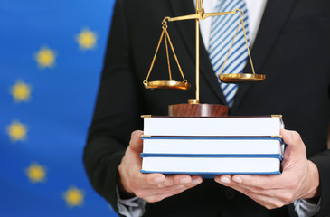 Man holding scales and law books on European Union flag background