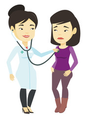 Doctor listening to chest of patient.