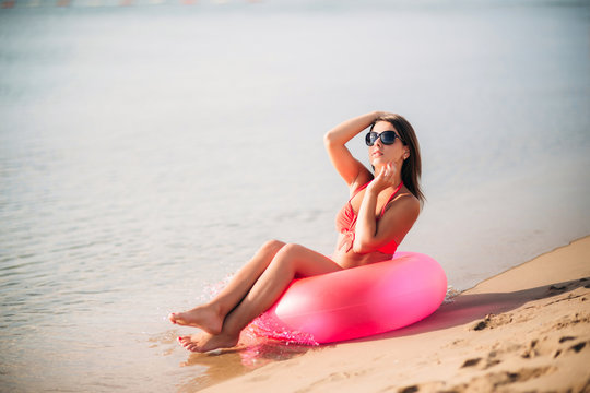Beautiful girl in a pink bathing suit, in the sea. Sunny weather. Summe