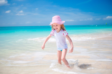 Adorable little girl at beach having a lot of fun in shallow water