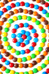 Swirl made of delicious candies on white background