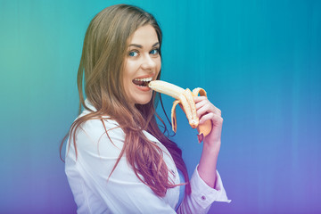 Young woman eat banana in order to feel happy.