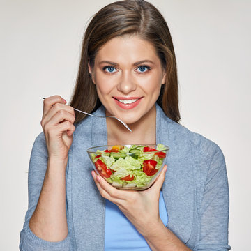 Smiling woman holding glass dish with salad.