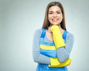 Woman builder standing against gray back.