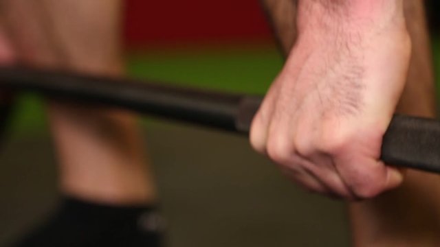 weighlifter grabbing a  weight in a gym. 