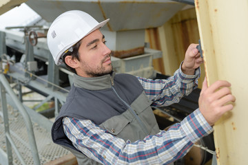 Man measuring metal structure