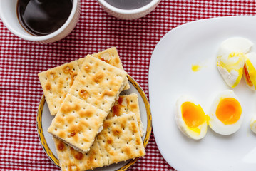 Two cups of coffee, cracker, egg, breakfast