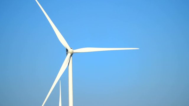 Many wind generators are spinning against the blue sky, close-up photography