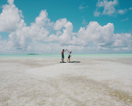 Couple holding hands and playing in shallow sea water