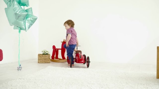 Small boy driving a toy car on the carpet