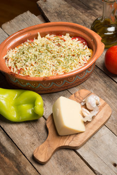 Uncooked Greek speciality Bujurdi in clay pot on rustic table