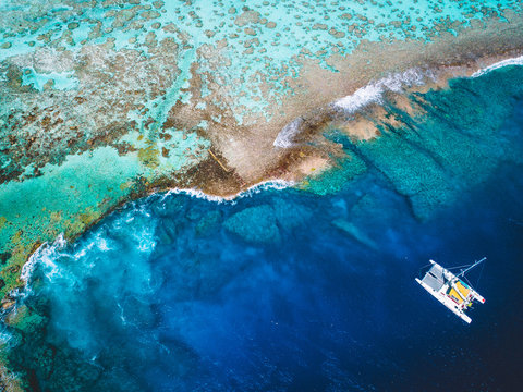 Aerial view of island coastline, boat on water near island, Tahiti, South Pacific