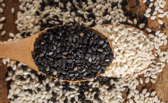 Fresh black and white sesame seeds in spoons